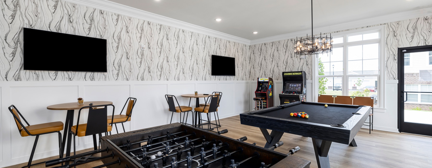 game room with tvs, pool table, arcade games and seating