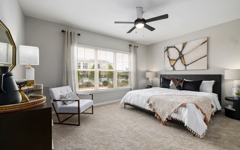 carpeted bedroom with ceiling fan and picture window